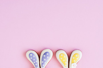 Easter background concept. Bunny ears cookies on a pink background.