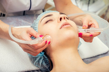Beautiful young woman getting a facial massage with her eyes closed at the Spa.