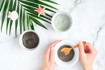 Preparing cosmetic clay mask in bowl. Natural organic SPA beauty products on marble background, facial skin care concept.