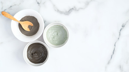 Cosmetic clay face mask in bowls on marble background. Natural organic SPA beauty products, facial...