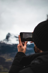 man taking picture on cell phone