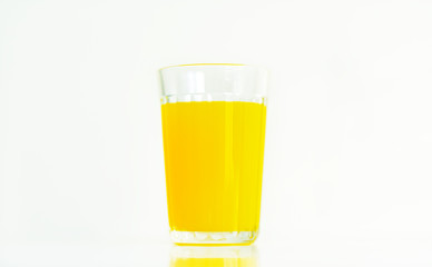 glass with yellow juice on a white background