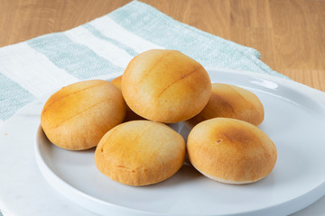 White plate with hot Pandebono. Traditional home-made cheese bread Buns from Colombia