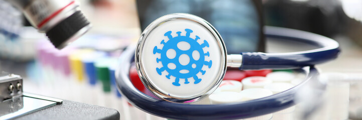 Medical stethoscope lying on set of vials at scientific lab