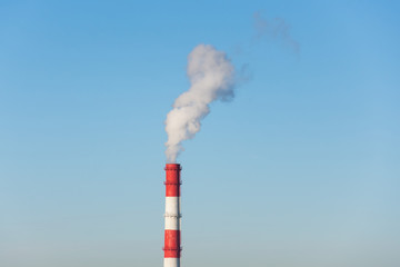 Smokestack Pollution in the air chimney on blue sky.