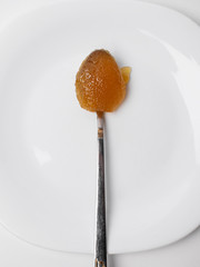  Spoon of honey on a white plate