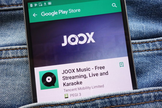 KONSKIE, POLAND - JUNE 09, 2018: JOOX app on Google Play Store website displayed on smartphone hidden in jeans pocket
