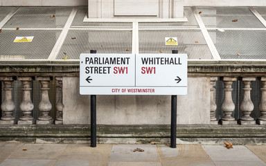 Whitehall, London SW1. A street sign dividing Parliament Street and Whitehall, the London district central to UK Government buildings.