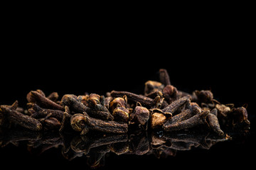 a lot of dried clove seeds on a dark background