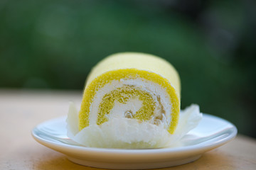 Sponge cake cream roll on white dish show bakery background