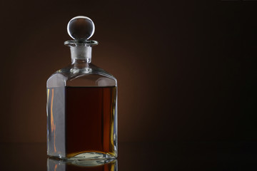 Bottle of whiskey on brown background
