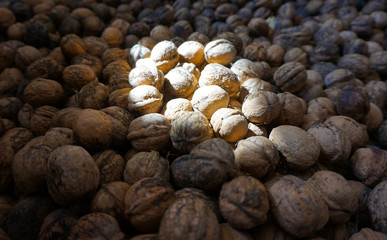 Background of walnuts peeled, a ray of sun falls on them.