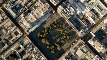 Obraz premium Top down aerial view of Arequipa's white city main square - UNESCO world heritage site - white sillar cathedral, geometric park, shadows of people walking