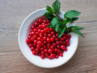 Red currant berries in a plate close up. Fresh ripe red currant top view. Eco food concept. Natural vitamins