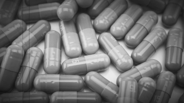 Vintage Close Up View of Capsules Moving Left to Right with Retro 8mm Effect Scratches and Noise. Black and White