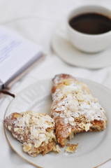 cup of coffee and almond croissants on white background