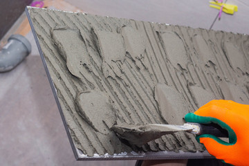 construction worker installing wall tile at home repair renovation work