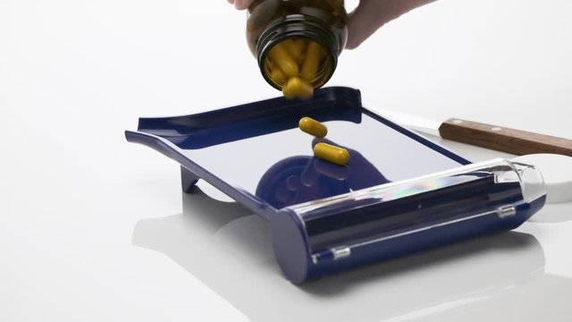 Slow Motion of Yellow Capsules Falling from Bottle on Pharmacist Blue Counting Pills Tray