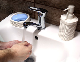Hand washing in the sink in the bathroom