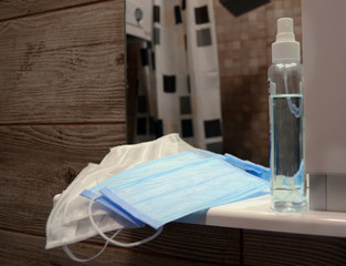 Medical masks and antiseptic on the shelf in the bathroom