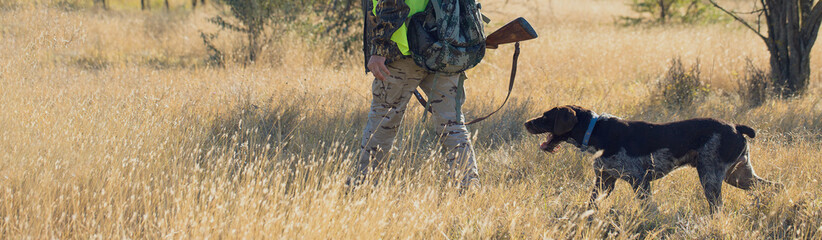 Hunter with a gun in his hands on the background of the steppe. Pheasant hunting in the early...