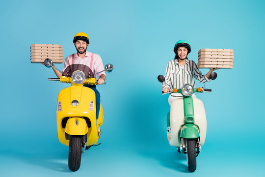 Full length photo of funky crazy lady guy drive two vintage moped carry pizza boxes courier occupation junk fastfood formalwear outfit protective helmet isolated blue color background