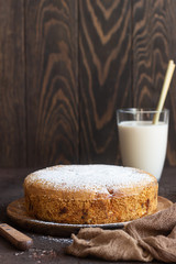Homemade delicious sponge or soft cake on a dark brown concrete background. Freshly baked Sharlotka, sponge apple cake.