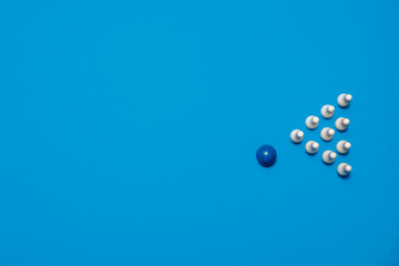 Bowling ball about to strike 10 bowling pins on a blue background with copy space and room for text with a right side composition