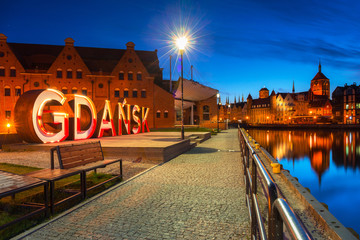 City of Gdansk outdoor sign over Motlawa river at dusk, Poland.