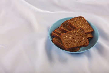 Healthy food. Sliced dark bread with grains in a blue plate