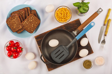 Healthy breakfast background with eggs, herbs, cherry tomatoes and dark bread