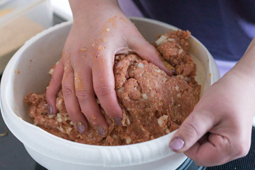 Gehacktes Mett für Frikadellen in der Schüssel kneten