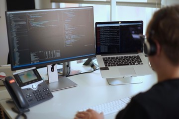 Real male web programmer coding javascript, php, symfony, react at work 