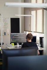Real male web programmer coding javascript, php, symfony, react at work 