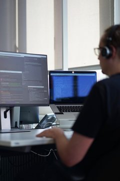Real male web programmer coding javascript, php, symfony, react at work 