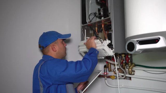 Man engineer with tablet computer repairing gas heater system