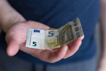 5 euro banknote. Man Hand holding cash paper money.Financial and money concept. job seeker. unemployed. 