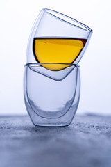 double glass espresso cups on black background with tea