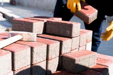 Workers lay paving tiles, construction of brick pavement, close up architecture background stock photo...