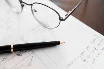 notebook with scribbles and glasses