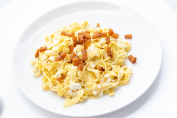 close up of fresh homemade pasta with cheese and fried bacon