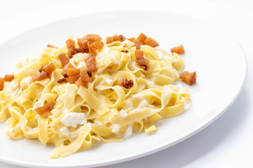 close up of fresh homemade pasta with cheese and fried bacon