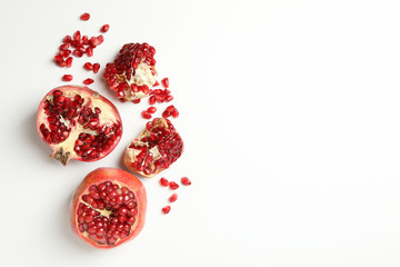 Pomegranate and seeds on white background, space for text