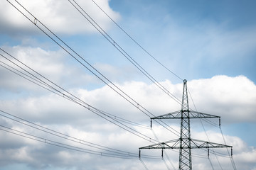 Fototapeta premium An electrical tower under a cloudy sky