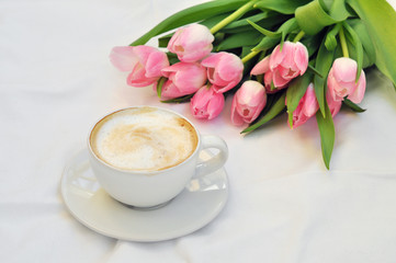 Obraz na płótnie Canvas cup of coffee and bouquet of tulips on white background