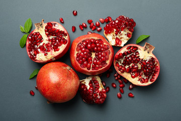 Pomegranate, leaves and seeds on gray background, top view