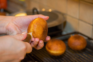 Injecting a donut with sweet apricot marmalade.