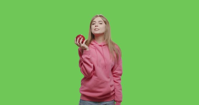 Young woman eating big fresh red apple over chroma key background