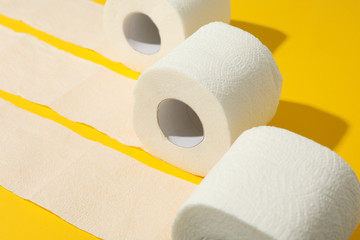 Toilet paper on yellow background, space for text