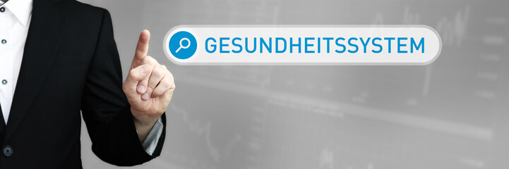 Gesundheitssystem. Mann im Anzug zeigt mit dem Finger auf ein Suchfeld. Das Wort Gesundheitssystem steht in der Suche. Symbol für Business, Finanzen, Statistik, Analyse, Wirtschaft